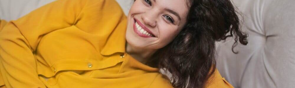 Woman in yellow top with a white smile